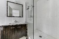 sleek white-tiled shower area in Paris luxury apartment
