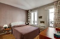 master bedroom with a queen-size bed and wooden floor in paris luxury apartment