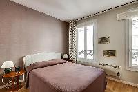 master bederoom with a queen-size bed in paris luxury apartment