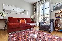 living area with red sofa bed and ghost round center table in paris luxury apartment