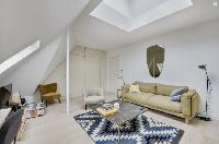 cozy living area with comfortable sofas, full of closets, and white painted eaves walls in Paris lux