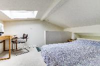 brand-new queen-size bed in the bedroom with sofa and study table beneath a skylight