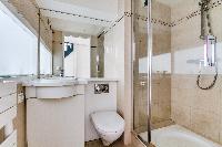 pale-painted bathroom with shower, toilet, and sink in a studio apartment in Paris