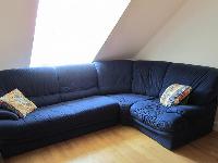 comfortable L-shaped blue sofa in a studio Paris luxury apartment