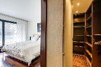 first bedroom with a double bed, a television, a walk-in closet in a 2-bedroom Paris luxury apartmen