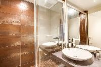 An en-suite bathroom fully-equipped with a toilet, a sink, and a shower area in Paris luxury apartme