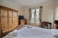first bedroom with an en-suite bathroom furnished with double sinks, a bathroom cabinet, mirrors, an