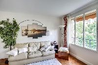 comfortable sofa, potted plants, lamps, and bright windows with the views outside in a 1-bedroom Par